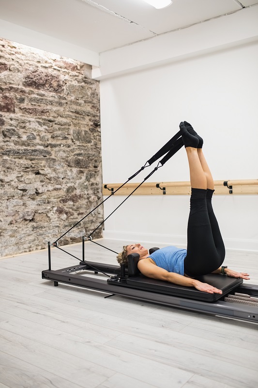 Woman exercising on reformer in gym